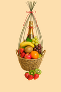 Fruit basket with a bottle of champagne on a beige background