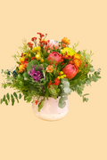 Colorful flower arrangement in a vase on a beige background