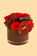 Floral arrangement with red flowers and a heart-shaped leaf in a brown container on a beige background
