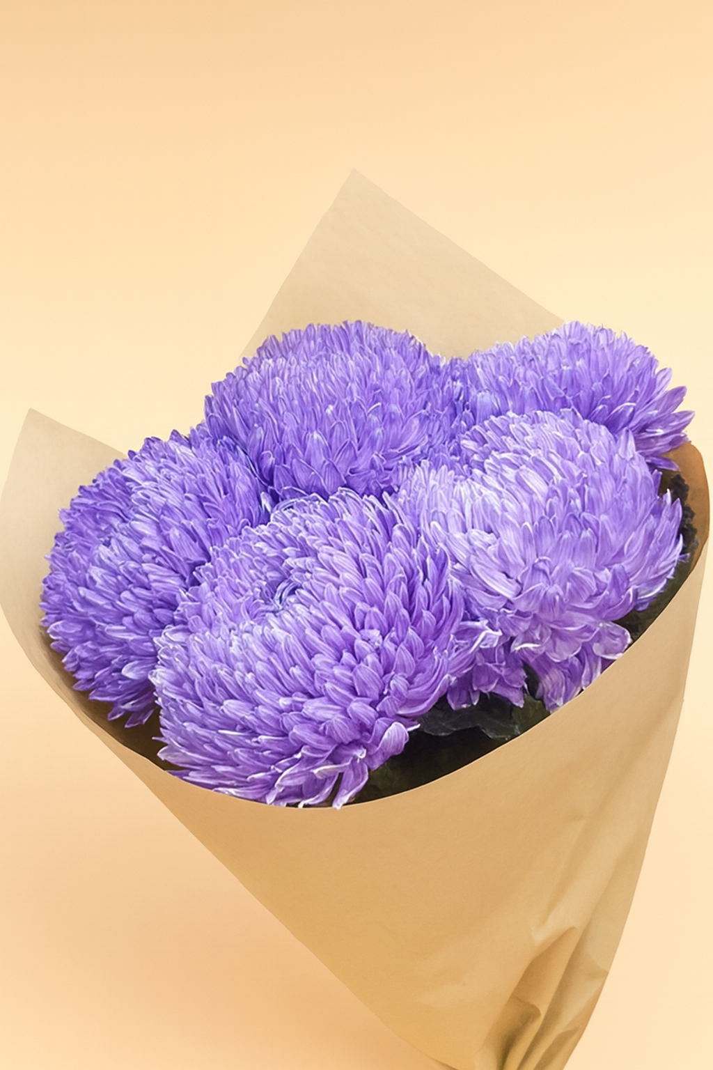 Bouquet of purple flowers wrapped in brown paper on a beige background